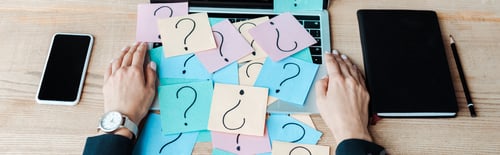 Preview: panoramic shot of woman near sticky notes with question marks on laptop