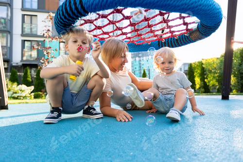 Preview: Mother Enjoys Playtime With Her Two Sons at the Playground on a Sunny Afternoon
