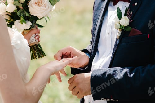 Preview: The hands of the groom wears a wedding engagement ring on the finger of the bride. Preparations.