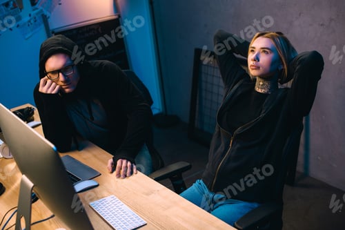 Preview: couple of thoughtful young hackers at workplace