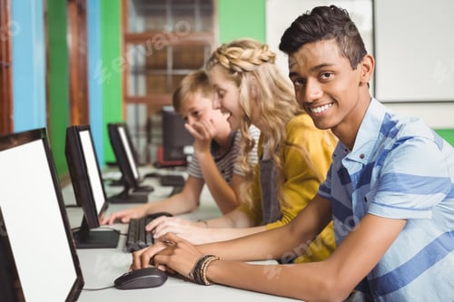 Preview: Smiling students studying in computer classroom