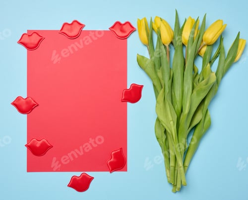 Preview: Bouquet of blooming yellow tulips with green leaves on a blue background, top view
