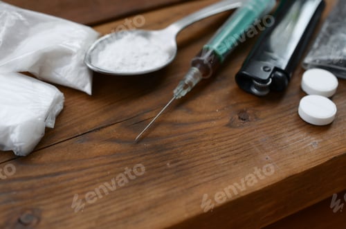 Preview: A lot of narcotic substances and devices for the preparation of drugs lie on an old wooden table