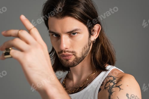 Preview: Portrait of young tattooed model looking at camera isolated on grey