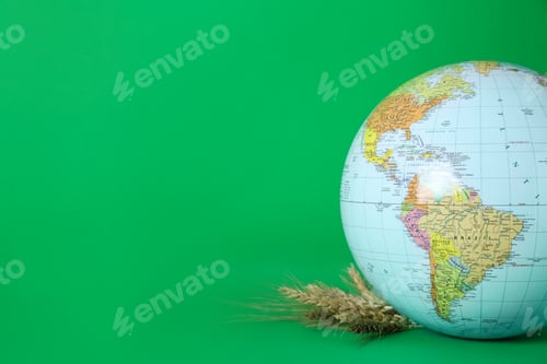 Preview: Globe with wheat spikelets on green background, space for text. Hunger crisis concept