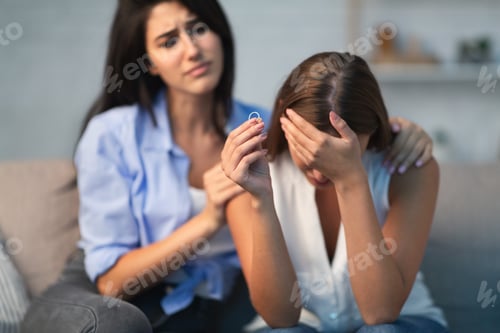 Preview: Compassionate Young Woman Supporting Depressed Divorced Friend At Home