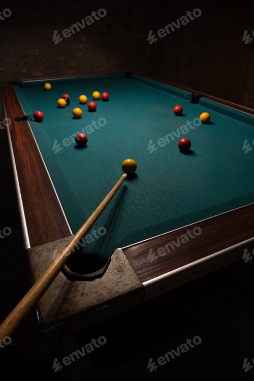 Preview: Vertical footage of a billiard table with balls and cue in a dark room