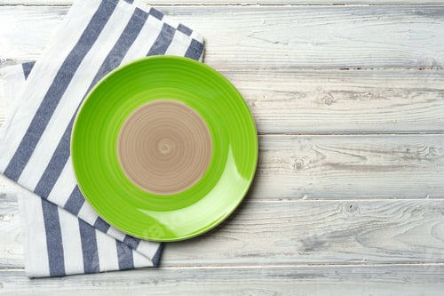 Preview: Top view of color ceramic plate on wooden background