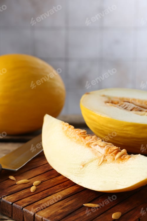 Preview: Cut and whole ripe melons on wooden table, closeup