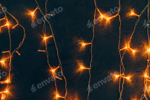 Preview: Warm light illuminated garland close up on dark background