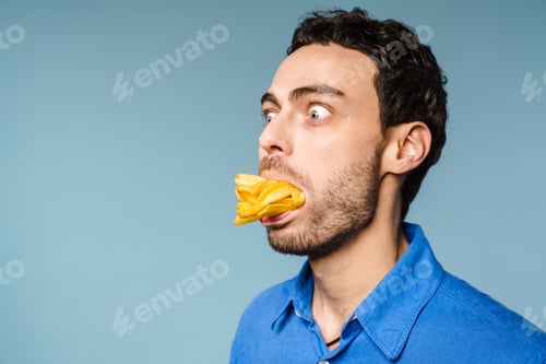 Preview: Shocked handsome guy posing with french fries in his mouth