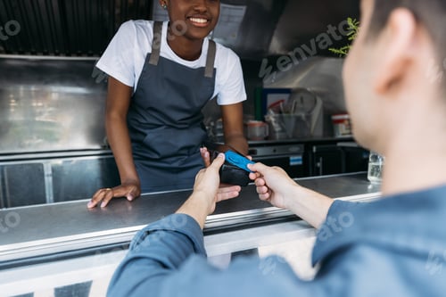 Preview: Close up of male customer apply a credit card to POS terminal at a food truck