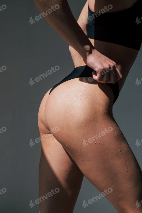Preview: Wet skin. Caucasian pretty woman stands against wall in the studio at daytime