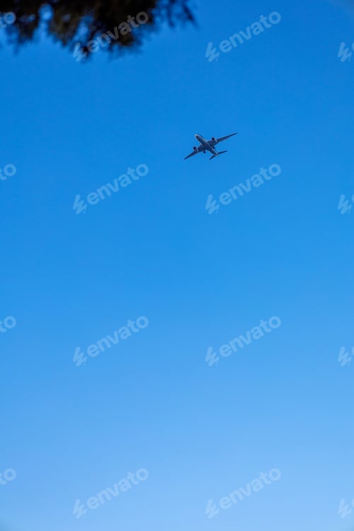 Preview: View of airplane flying in blue sky. Vertical photo