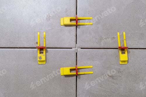 Preview: Plastic clips and wedges securing tiles in place for perfect alignment.