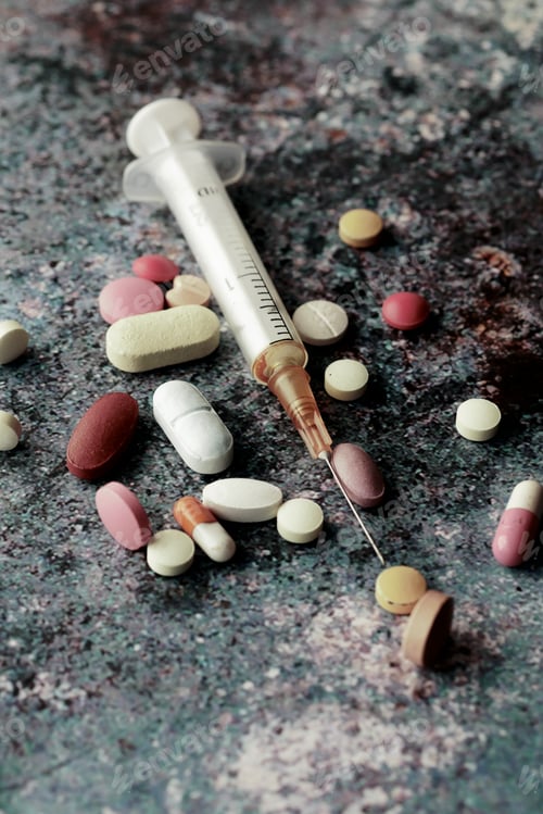 Preview: syringe and pills on dark background, close up