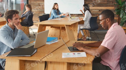 Preview: Business Team Using Laptops Hot Desking In Modern Office
