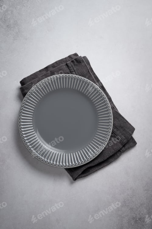 Preview: A ceramic dark gray plate with a linen napkin on a concrete background.