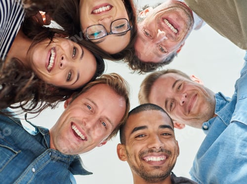 Preview: Low angle shot of six people putting their heads together in a circle