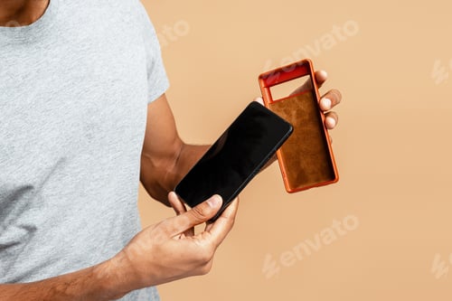 Preview: Man holding smartphone and colorful protective case