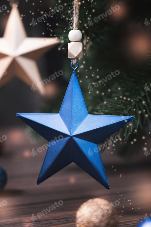 Preview: Christmas composition with blue and beige stars, fir tree branches on blurred brown background.
