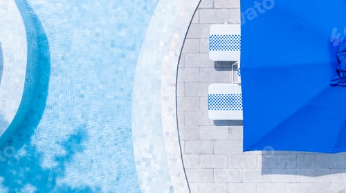 Preview: Top view swimming pool blue water in summer with umbrella pool and deck beach chair.