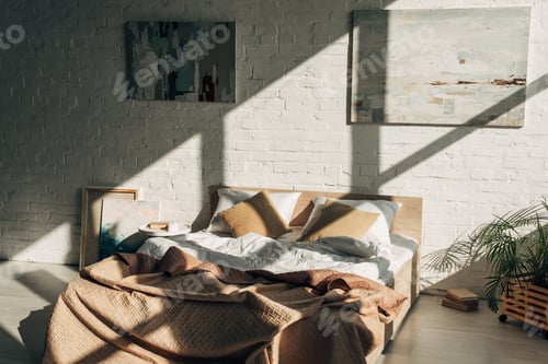 Preview: bedroom interior with bed, pillows and paintings in sunlight with shadows
