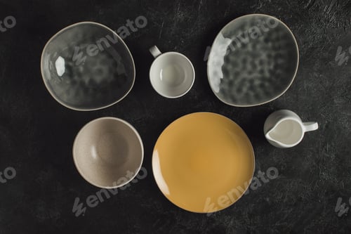 Preview: flat lay with ceramic plates, cup and jug isolated on black table