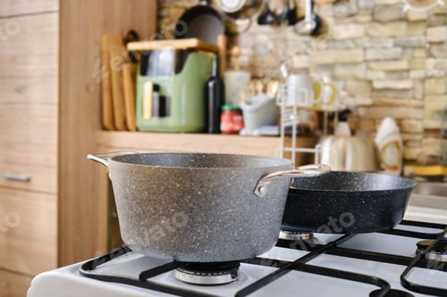 Preview: Cooking utensils on a stove in a modern kitchen with stylish decor and natural elements
