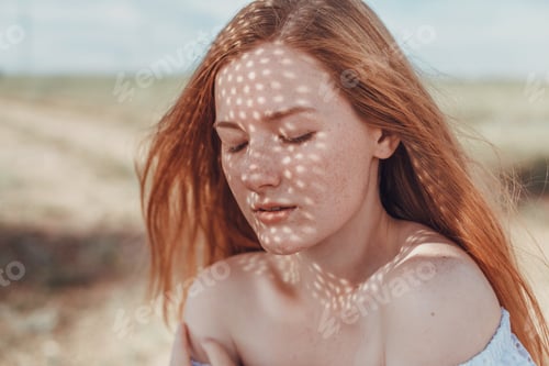 Preview: A beautiful redheaded woman in a white dress and hat on a sweltering day