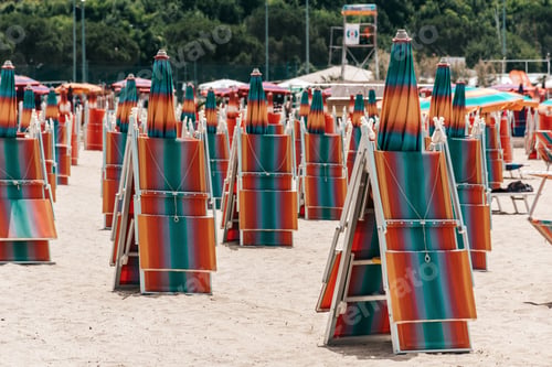 Preview: Folded deck chairs and parasols on sandy beach in summer resort in Portoroz, Slovenia