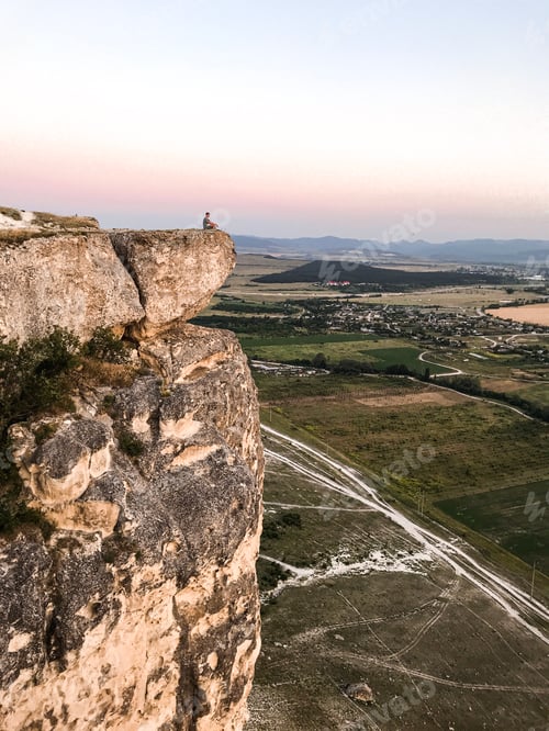 Preview: Man silhouette meditating on a high cliff