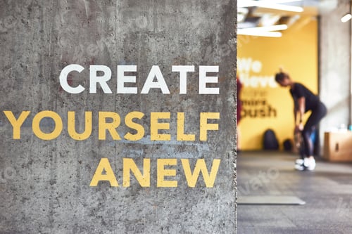 Preview: Fitness motivation quote Create Yourself Anew written on grey beton wall at gym, people working out