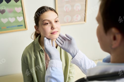 Preview: Doctor Examining Young Woman's Throat in Clinic