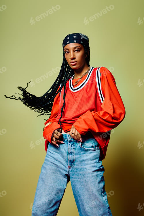 Preview: A young woman with braided hair showcases her stylish outfit while exuding confidence.