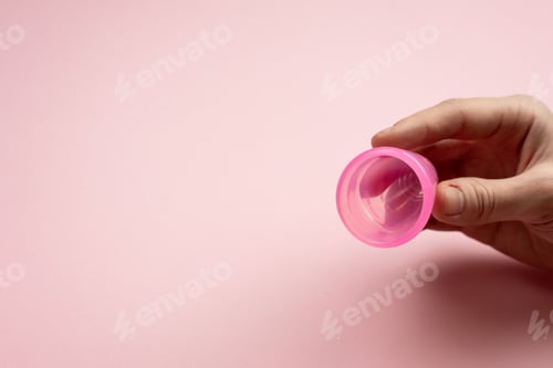 Preview: Close-up of young woman hands folding a menstrual cup.