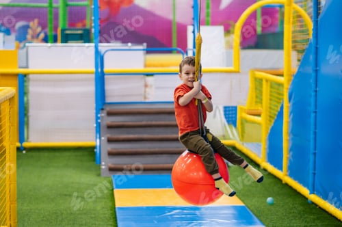 Preview: A cheerful little boy rides an amusement ride at a children's entertainment center