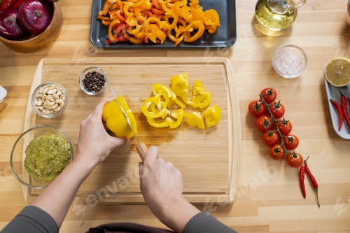 Preview: Overview of female hands chopping fresh yellow capsicum