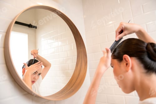 Preview: Woman Combs Hair in a Brightly Lit Bathroom