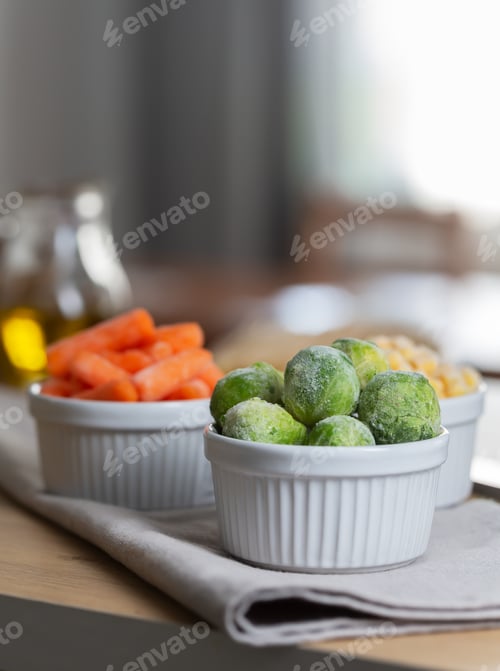 Preview: Baby carrot and and Brussels sprouts in the bowls on the kitchen table, close up