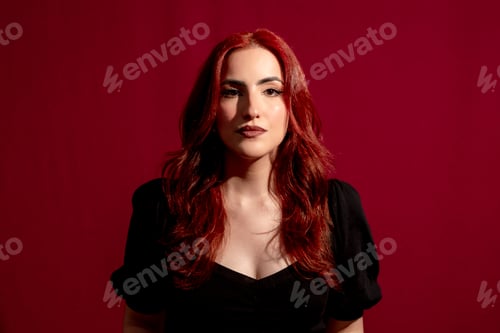 Preview: Stylish woman looking at camera while posing on an isolated background.