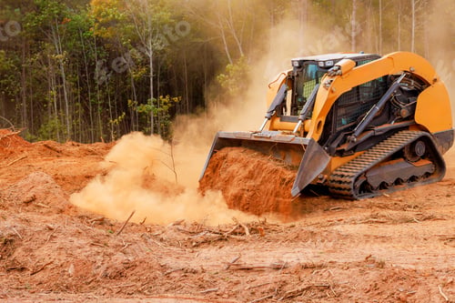 Preview: Excavator moves dirt in forested area while creating space for construction work during daylight