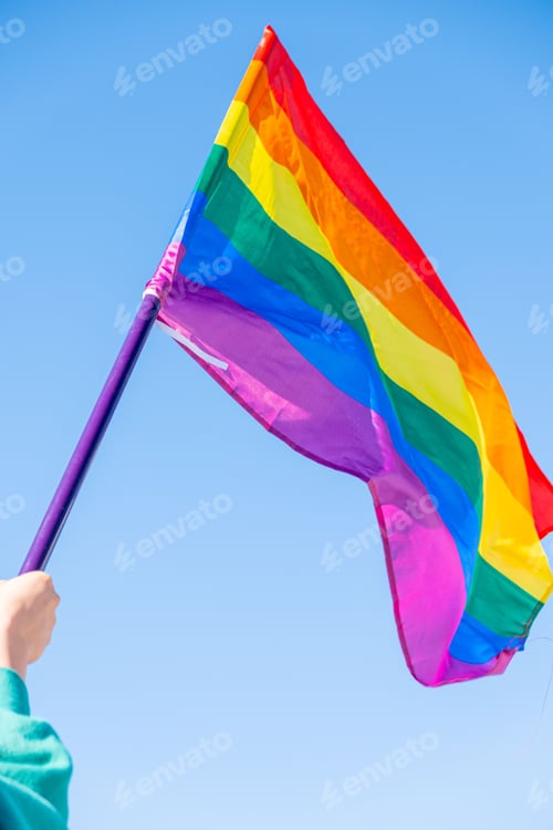 Vorschau: Arm einer Person, die eine Flagge mit Regenbogenfarben zur Unterstützung der LGBTI-Personen hält.