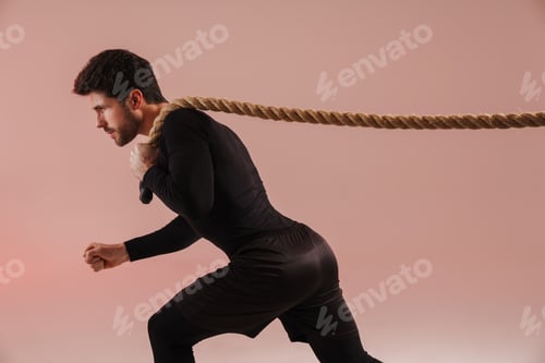Preview: Confident young brunette sportsman pulling rope