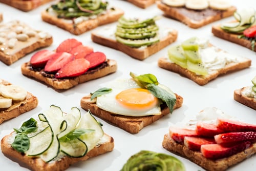 Preview: Toasts with cut fruits, fried egg and peanuts on white
