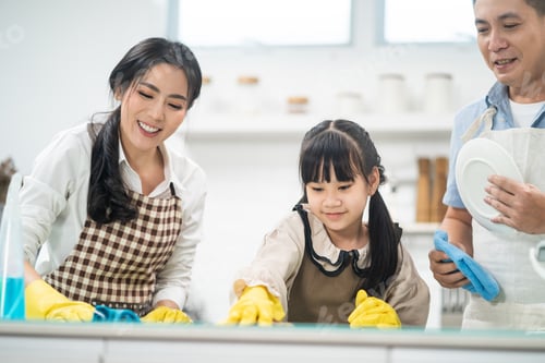 Preview: Asian young family teaching their daughter to clean kitchen counter.