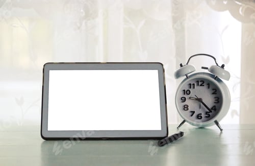Preview: Business desk at home closeup window view : Technology tablet and vintage alarm clock on wood table