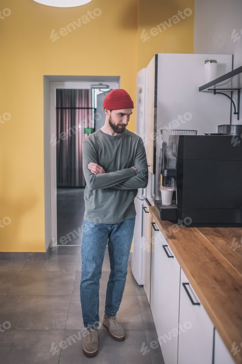 Preview: Guy with folded hands near coffee machine in office