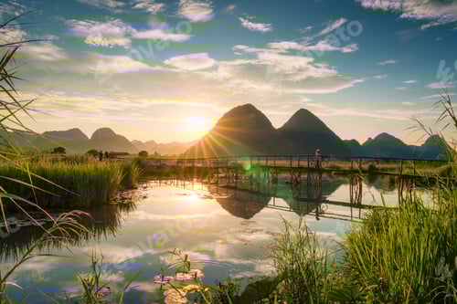 Preview: Sunset shining over mountain with villager pushing bicycle, fishing on wooden bridge over the river
