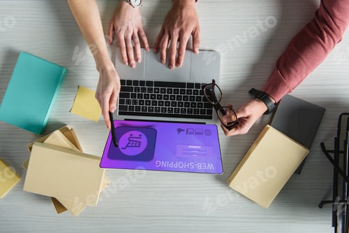 Preview: cropped view of woman pointing at laptop with web shopping website on screen near man holding